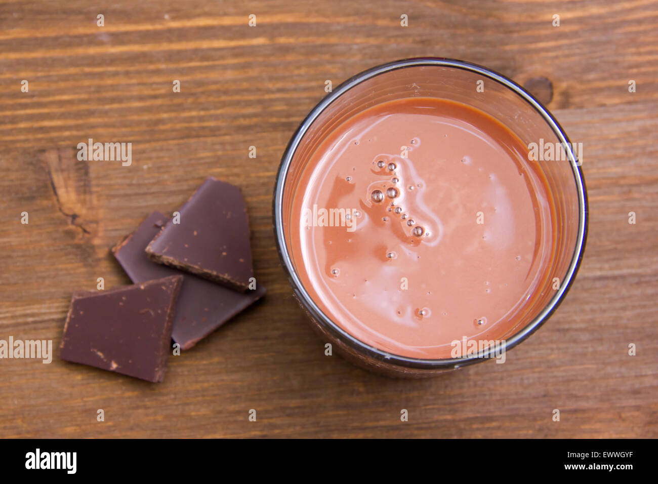 Glas mit Kakaogetränk auf Holztisch von oben gesehen Stockfoto