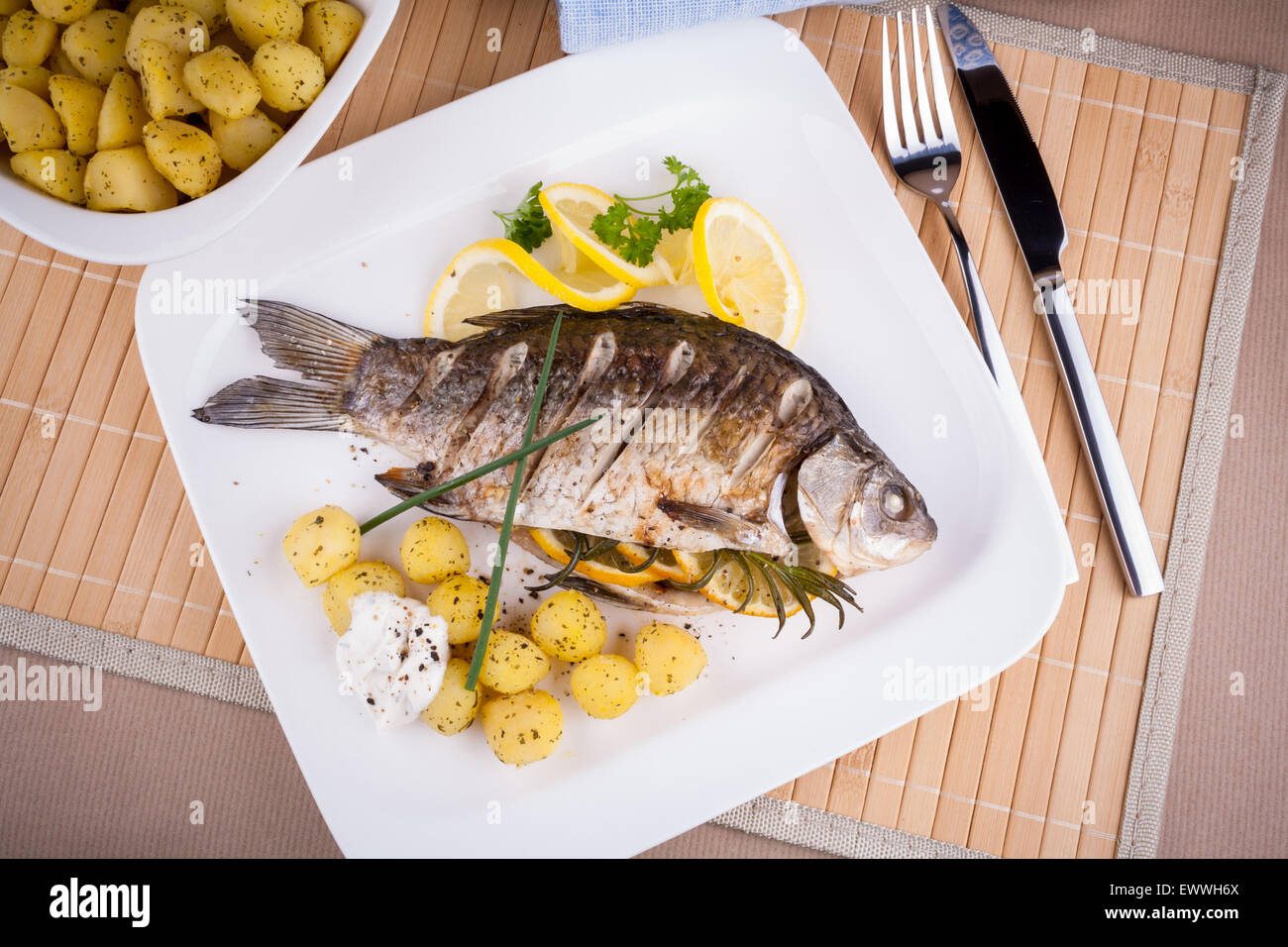 Gegrillter Karpfen mit Rosmarinkartoffeln und Zitrone, Ansicht von oben Stockfoto