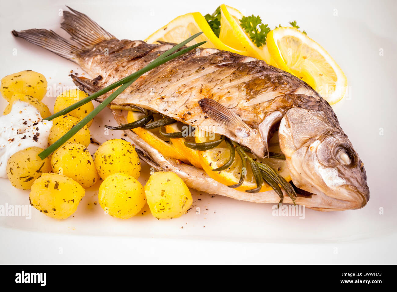 Gegrillter Karpfen mit Rosmarinkartoffeln und Zitrone, Nahaufnahme Stockfoto