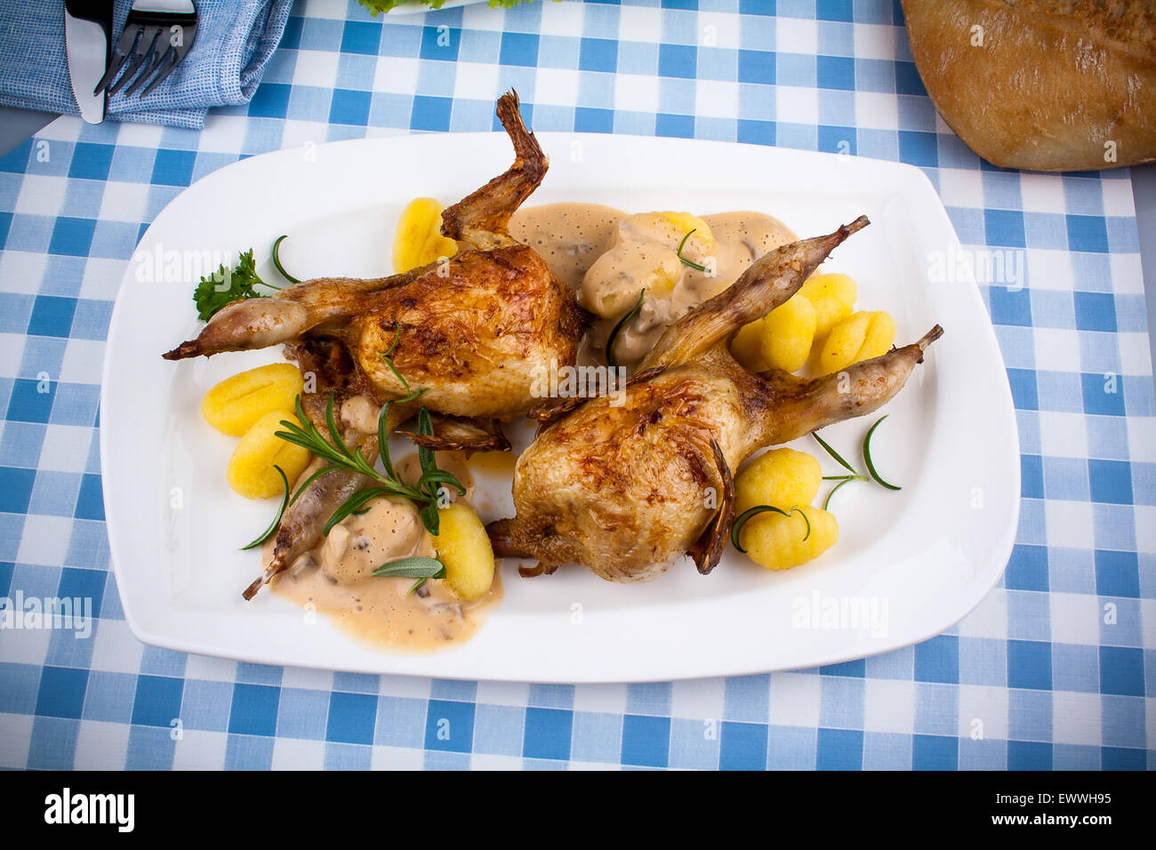 Zwei gebratene Wachtel mit Gnocchi, Soße und Rosmarin, Ansicht von oben ...