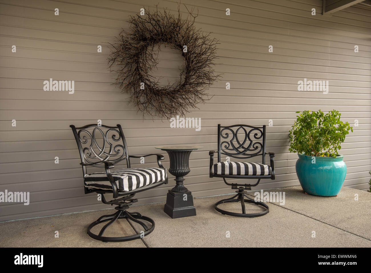 Schwenken terrasse Stühle, Tisch mit Glasplatte und Zweig wreathe auf der Veranda Stockfoto