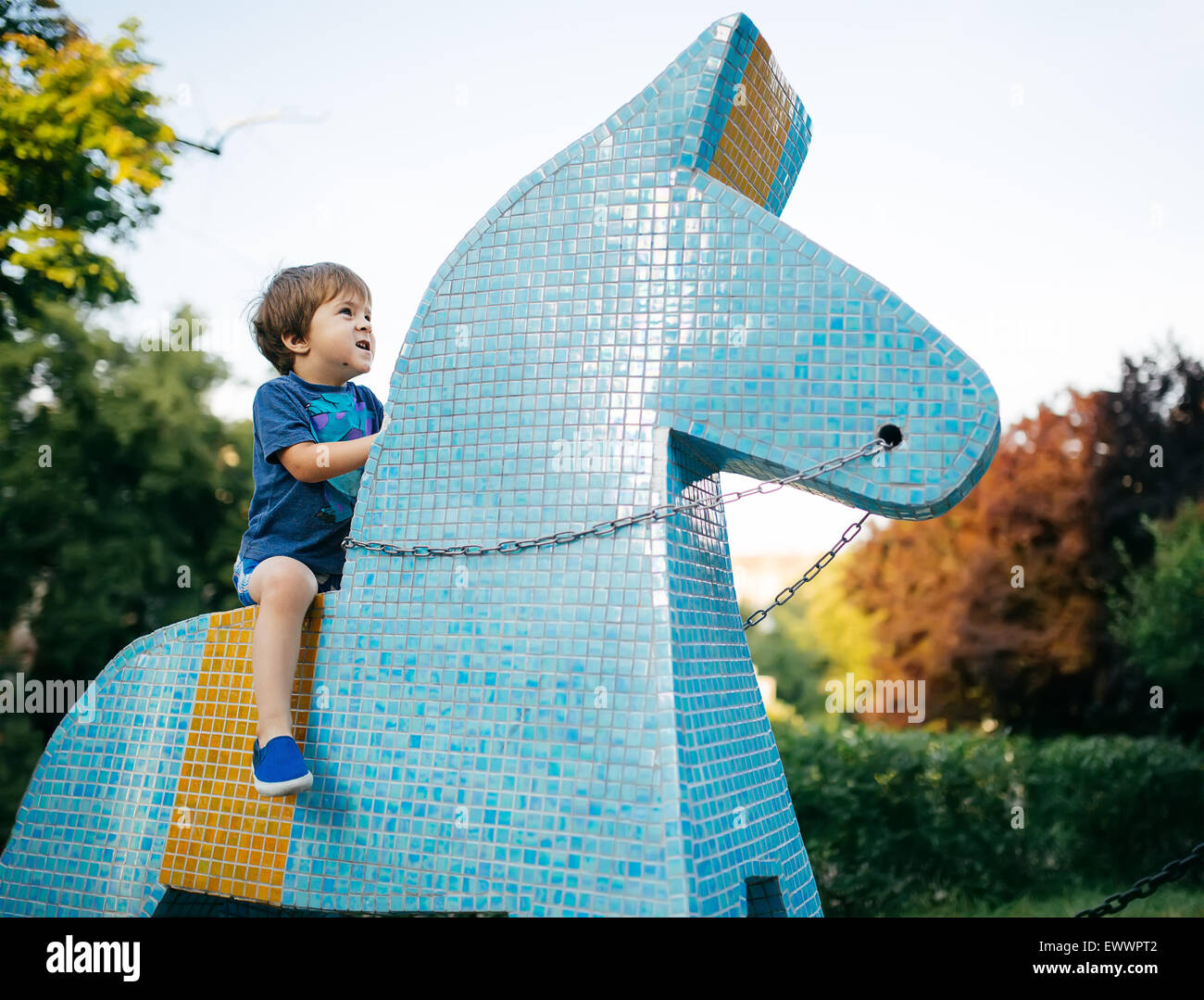 Kleiner Junge reitet Spielzeug Pferd keramischen Fliese Stockfoto