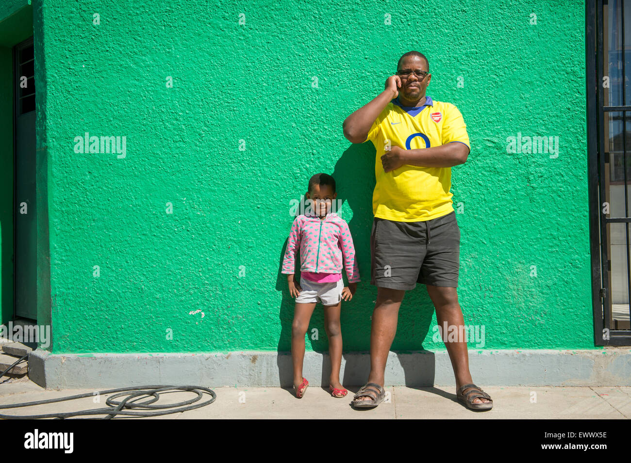 Namibia, Afrika - Mann und junges Mädchen stehen wieder hell grüne Wand. Stockfoto