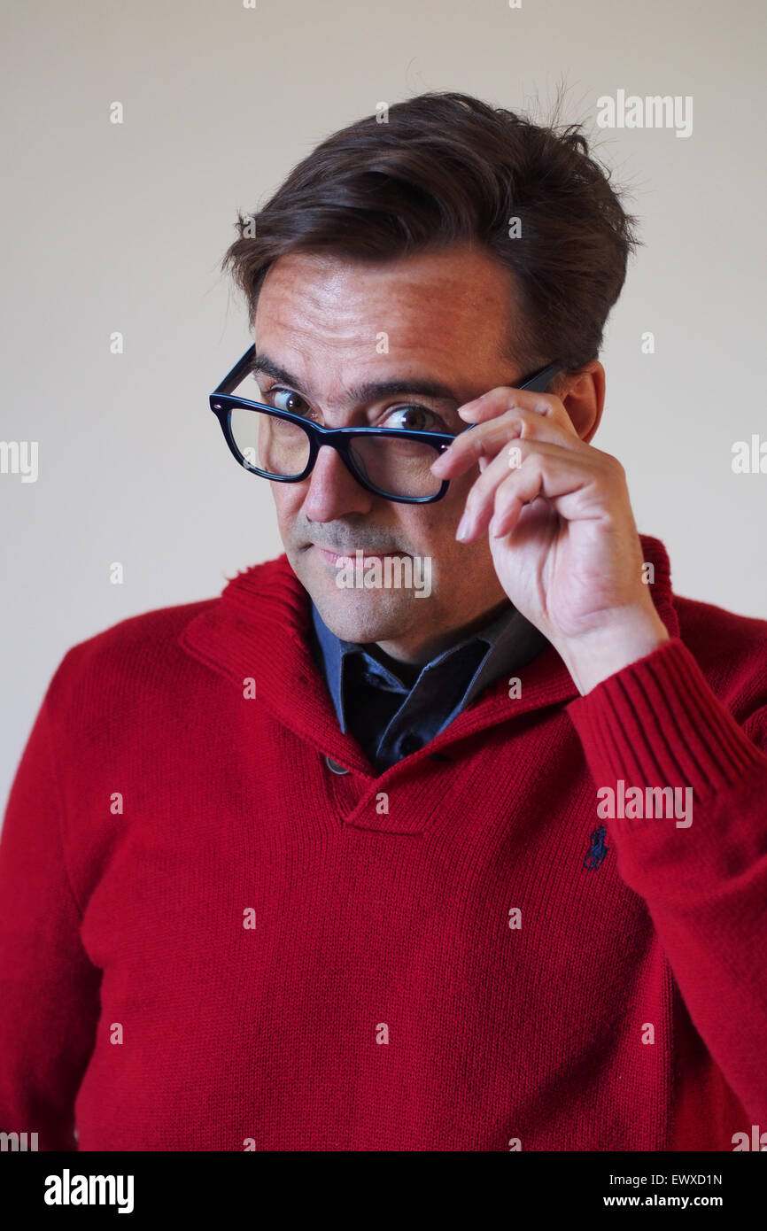 Hübscher Mann mittleren Alters mit Blick auf Gläser Stockfoto