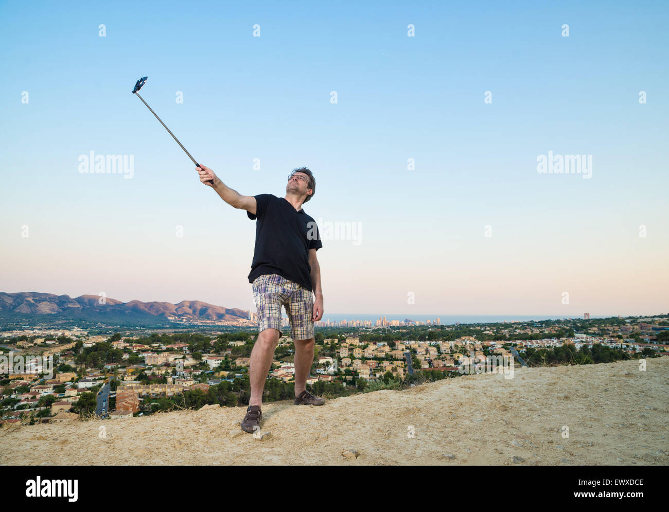 Kerl mit Selfie Stick versuchen, cool aussehen Stockfoto