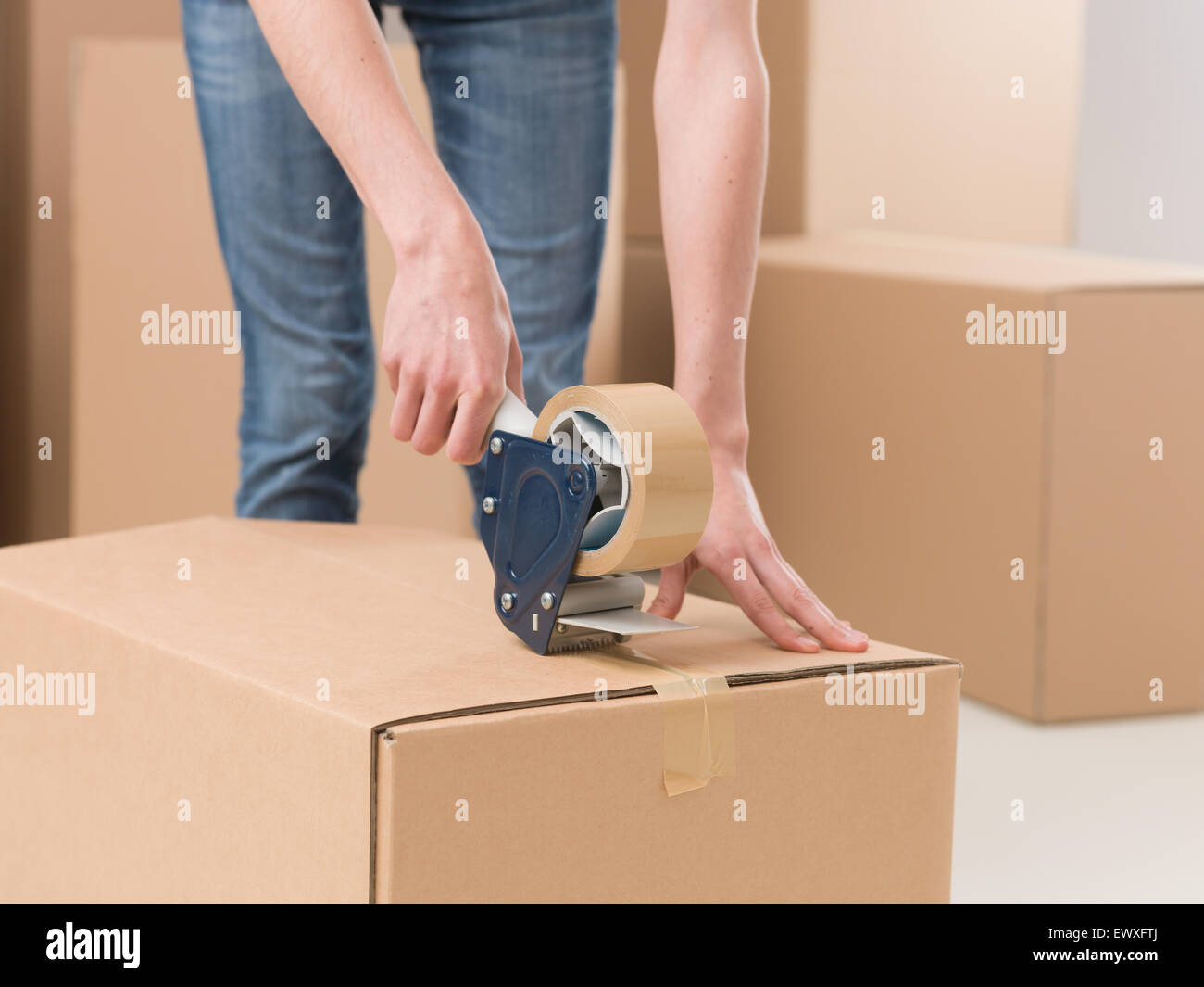 Nahaufnahme der weiblichen Abdichtung Karton mit Klebeband Stockfoto
