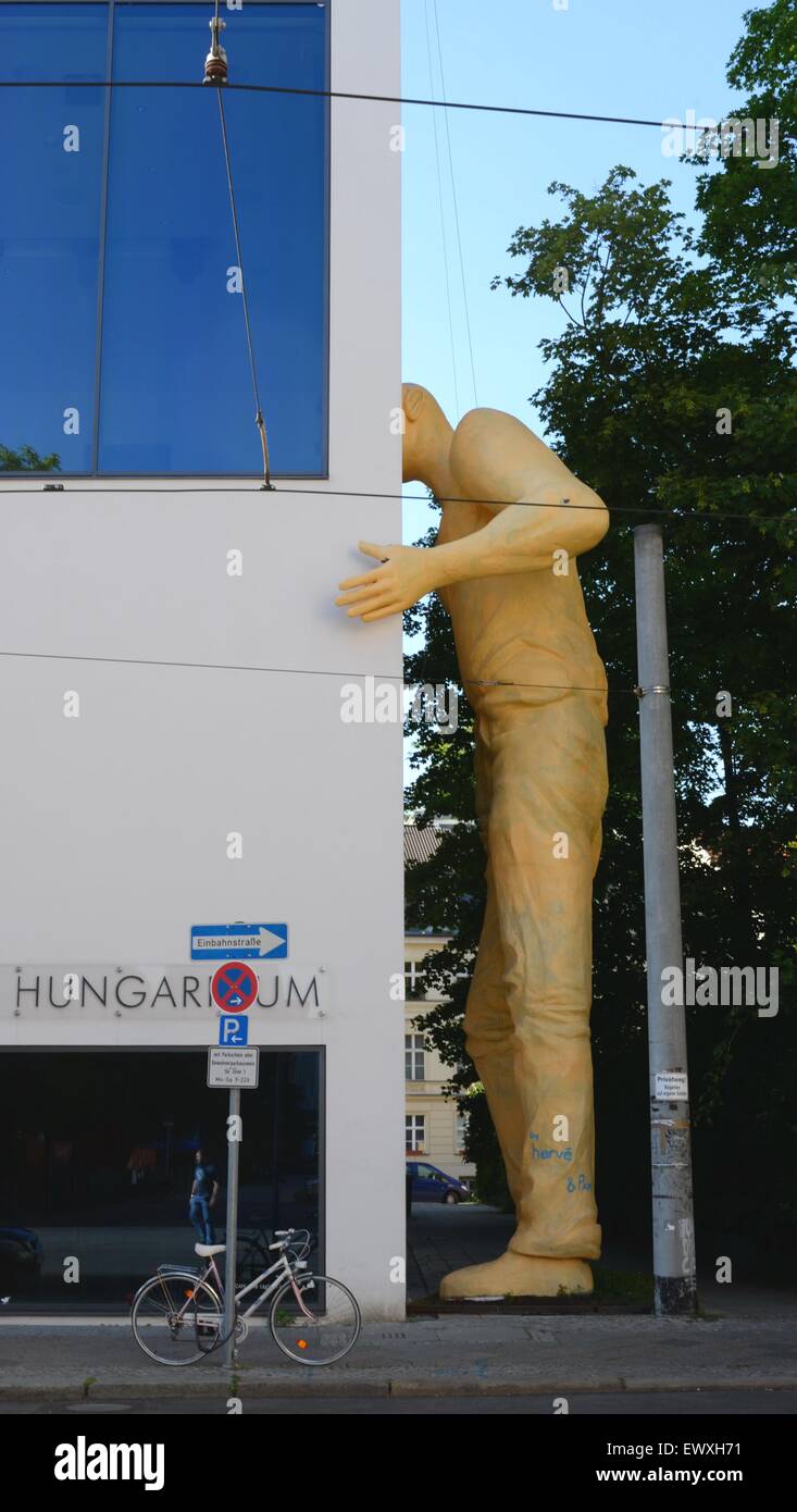 Moderne Kunstskulptur eines Riesen, der durch das Fenster im ersten Stock in einer Straße in Berlin gucken kann Stockfoto