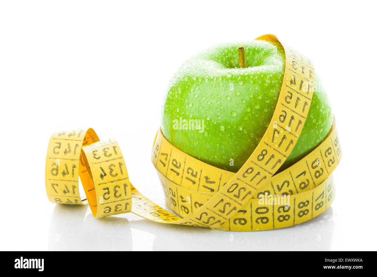 Grüner Apfel mit Maßband auf weißem Hintergrund Stockfoto