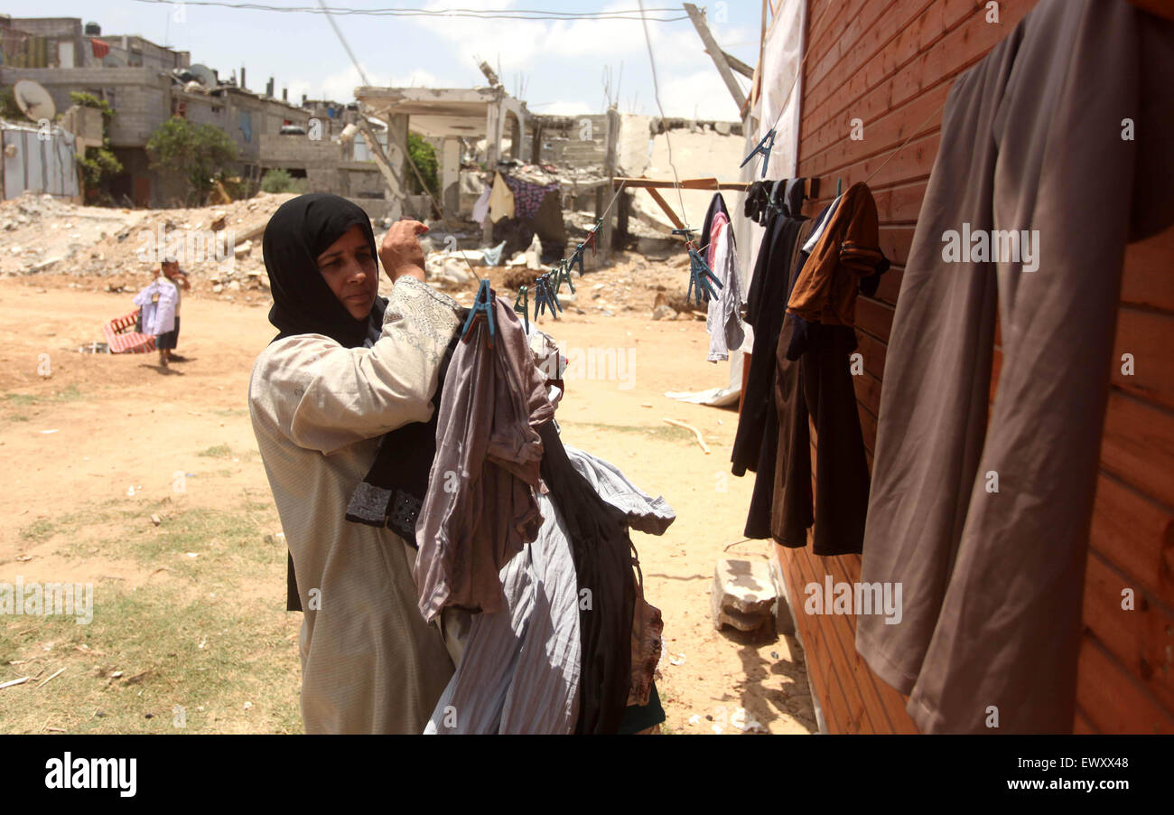 Khan Younis, Gazastreifen, Palästinensische Gebiete. 2. Juli 2015. Eine Palästinenserin sammelt Wäscherei in der Nähe der Ruinen von ihrem Haus, die Zeugen sagten durch israelischen Beschuss in einem 50-Tage-Krieg letzten Sommer in Khan Younis im südlichen Gazastreifen 2. Juli 2015 zerstört wurde. Robert Turner hat keine schnelle und einfache Antwort gefragt, um die schlimmsten Zeiten in seinen drei Jahren laufenden Hilfsmaßnahmen der Vereinten Nationen in Gaza Credit zu nennen: Ashraf Amra/APA Bilder/ZUMA Draht/Alamy Live News Stockfoto