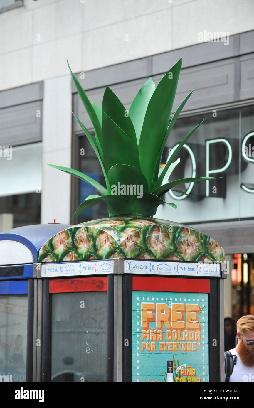 Oxford Street, London, UK. 2. Juli 2015. Eine rote Telefonzelle dekoriert Ananas oben werben "Tag der nationalen Pina Colada Stockfoto