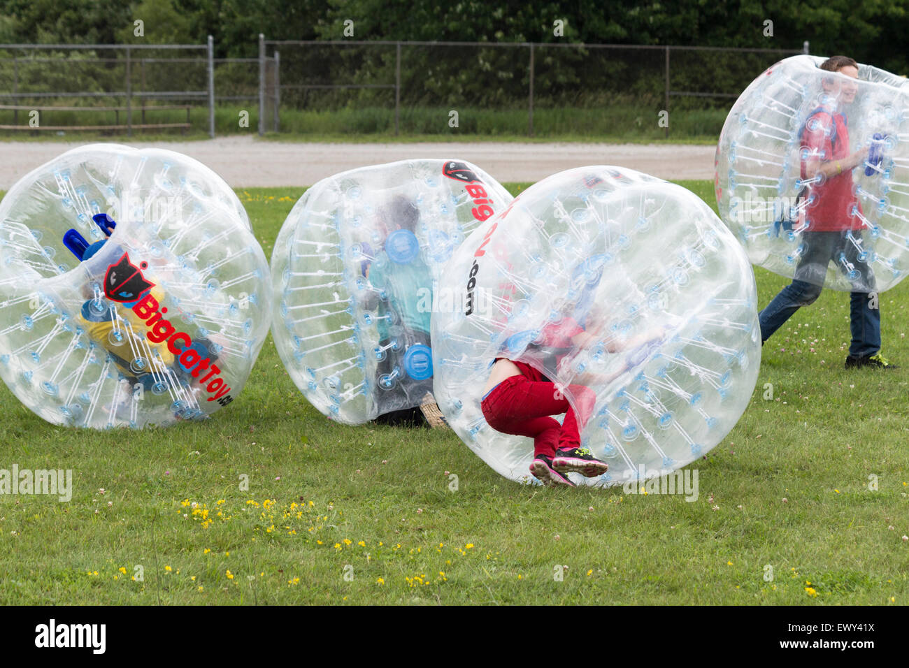 Vier Jungs im Teenageralter stoßen einander mit Stoßkugeln in Cannington, Ontario am Canada Day Feierlichkeiten Stockfoto