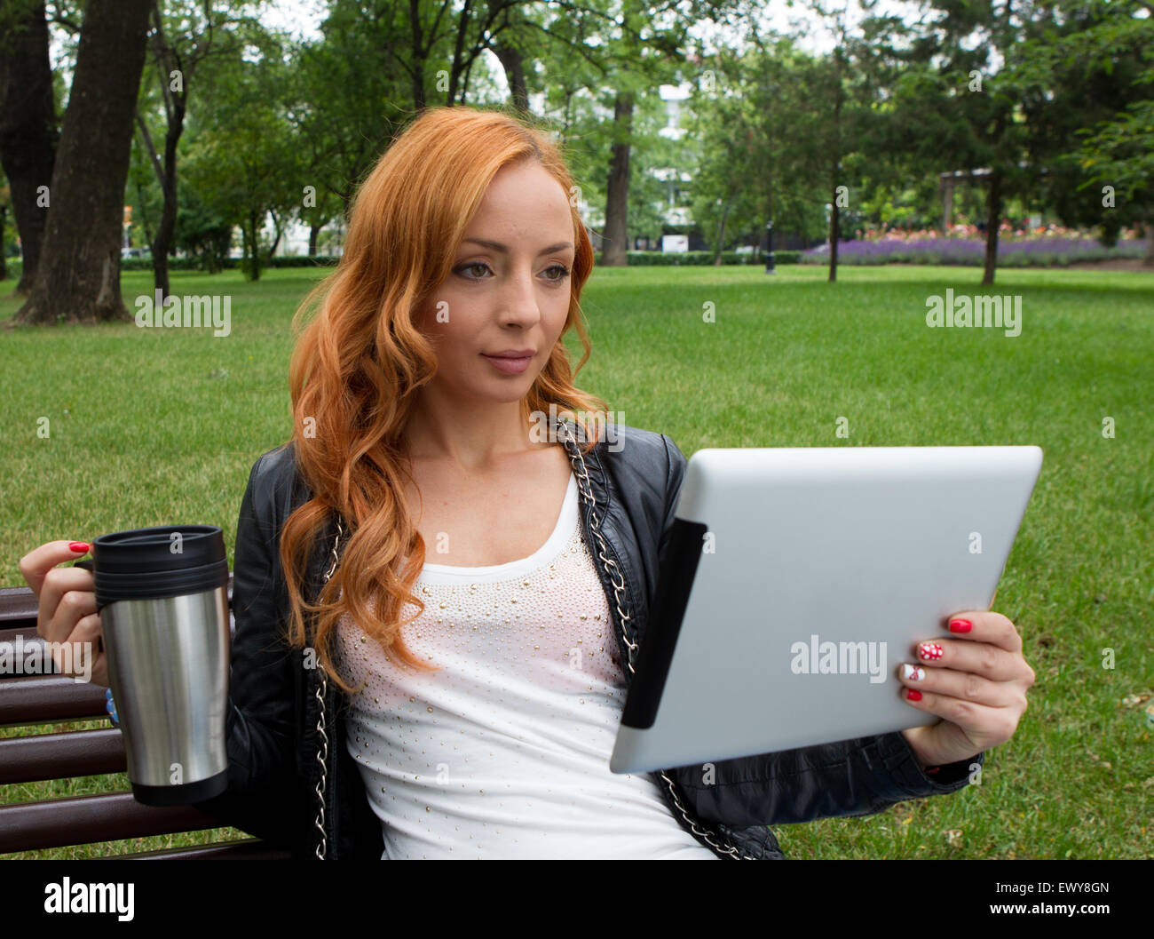 Schöne junge Mädchen mit Tablet im park Stockfoto