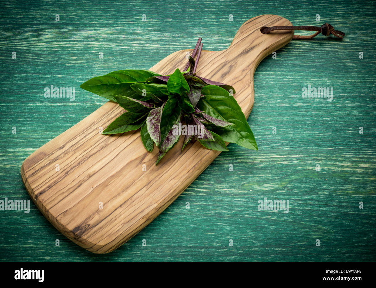 Reihe von frischem Bio Basilikum in Olivenöl Schneidebrett auf rustikalen hölzernen Hintergrund Stockfoto