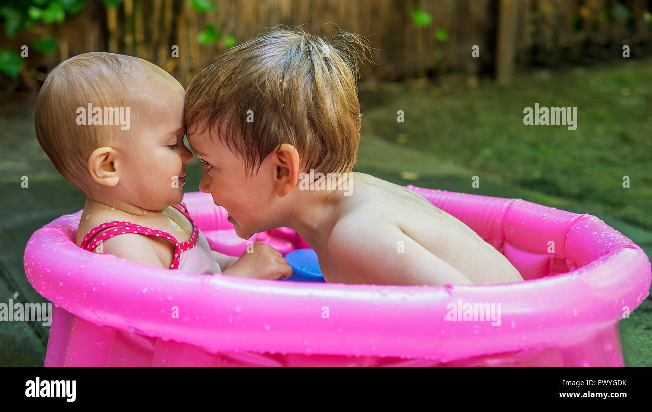 niedlichen Geschwister sitzen in einem Mini-pool Stockfoto
