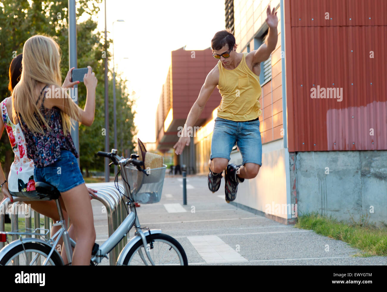 Outdoor Portrait junger Mann mit Rollschuhen springen und Mädchen fotografieren. Stockfoto