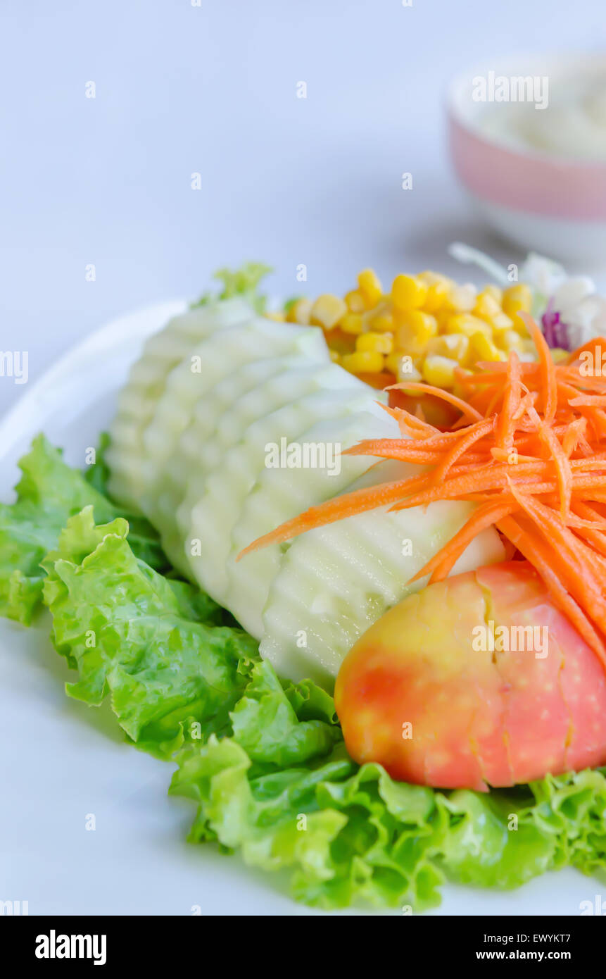 frischer Salat mit Früchten und gemischtes Gemüse auf Teller serviert mit weißen Sahne-sauce Stockfoto