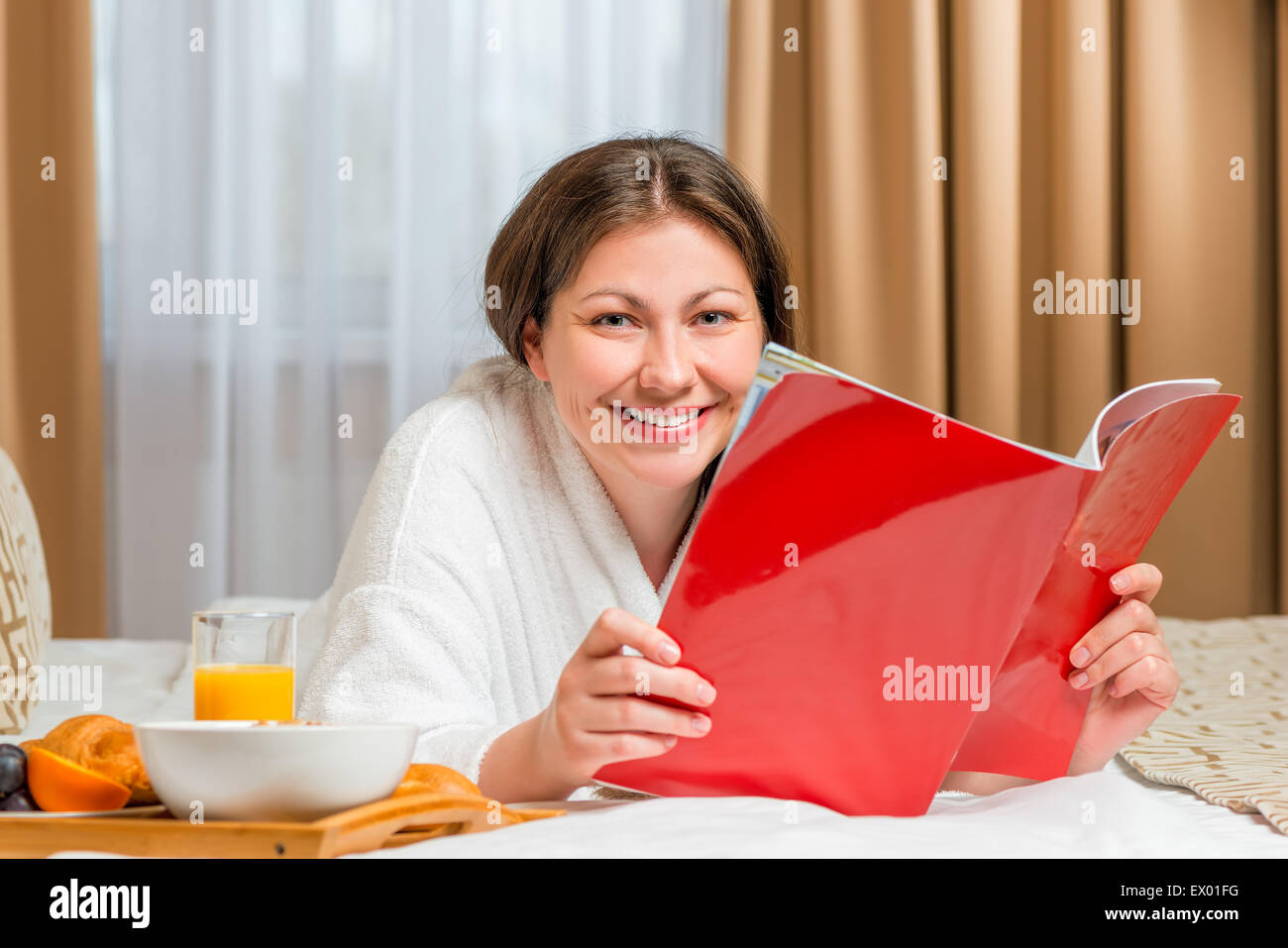 Lesen einer Zeitschrift auf dem Bett in den Morgen Stockfoto
