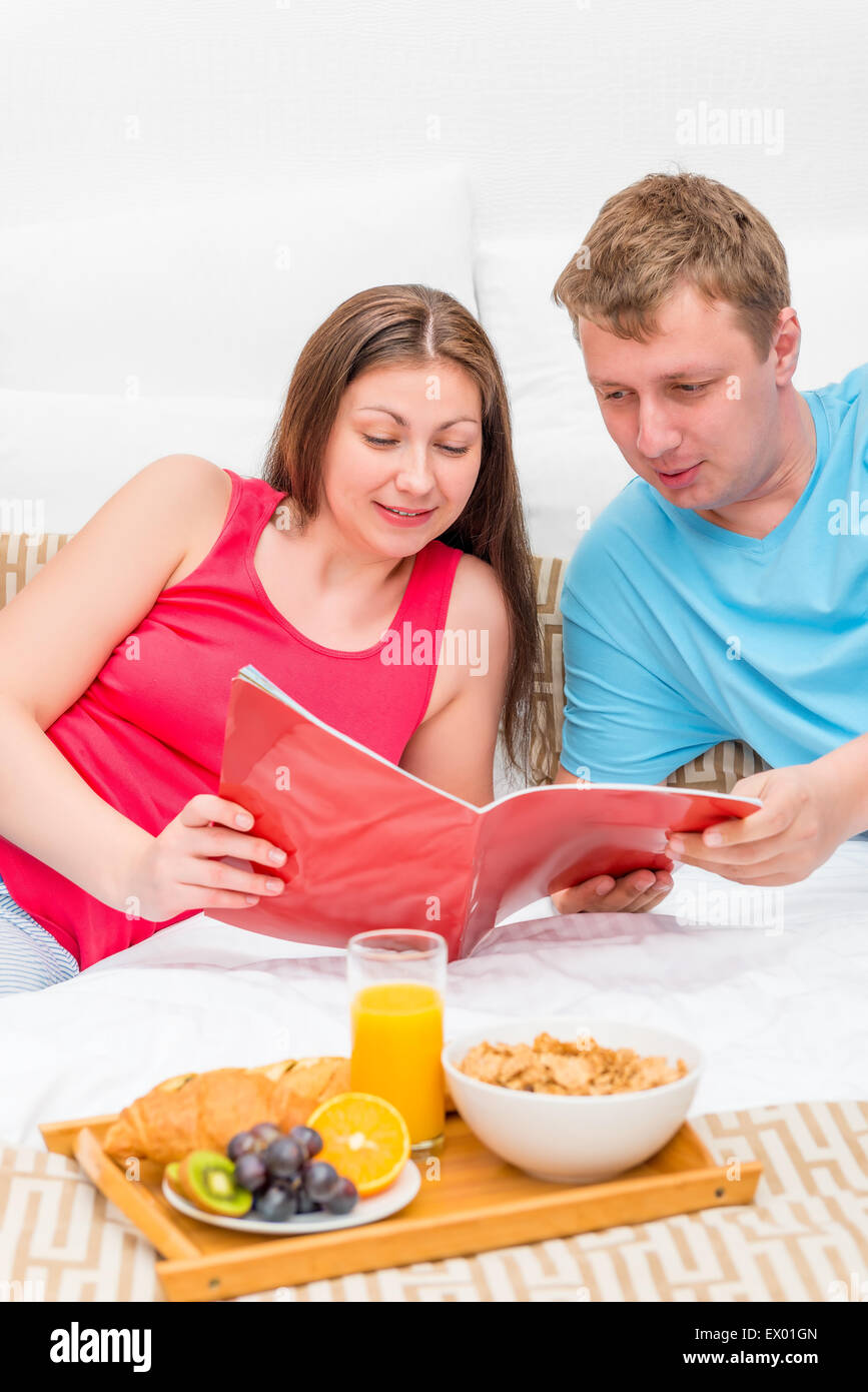 Frau und Mann, ein Magazin im Bett am Morgen Stockfoto