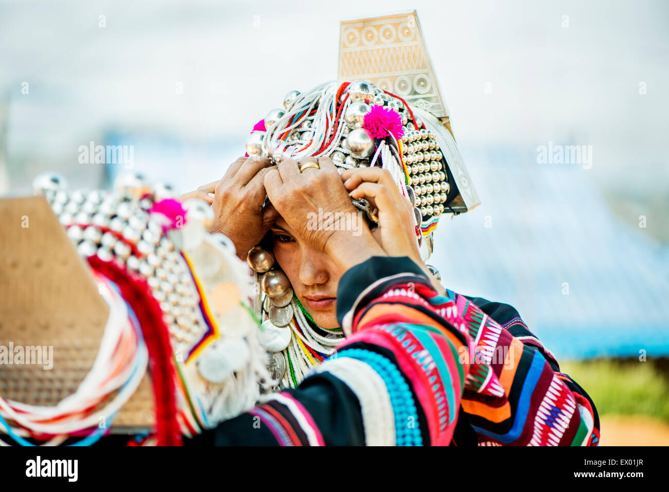 Akha jungen Frau geholfen, auf ihre traditionelle Kleidung in Mae Salong Dorf, Thailand, Asien. Stockfoto