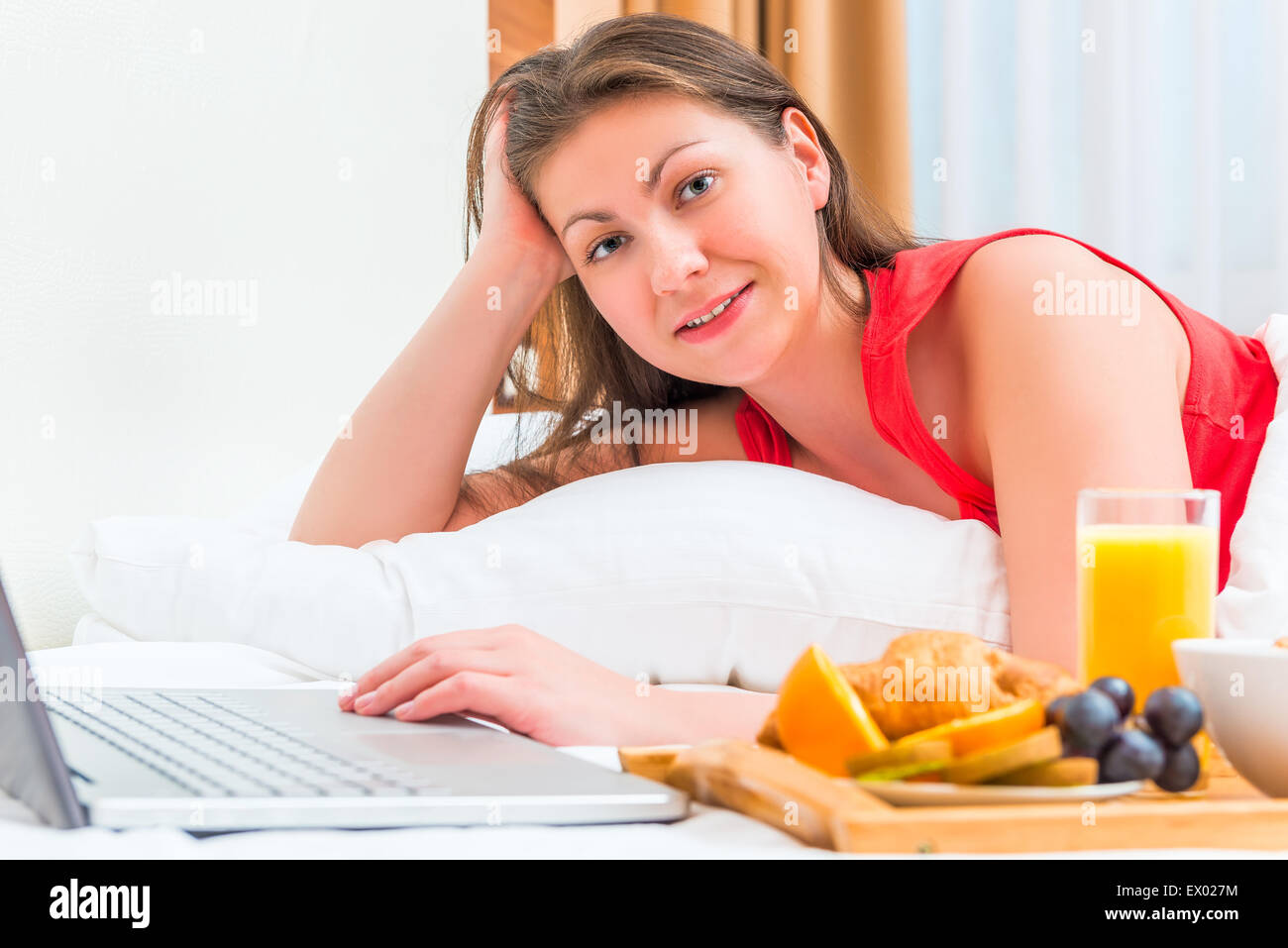 Mädchen der Europäischen Erscheinung mit einem Laptop im Bett Stockfoto