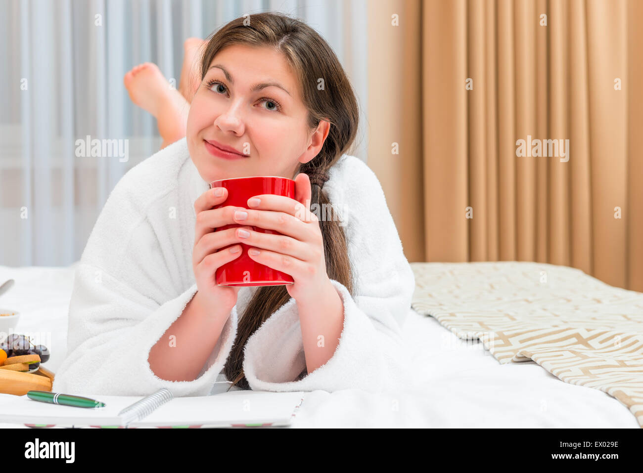 Mädchen mit einer Tasse Kaffee im Bett am Morgen träumen Stockfoto