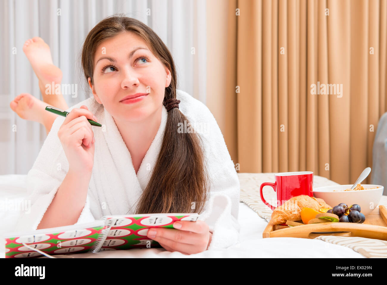 junge Frau mit einem Notebook und Frühstück im Bett Stockfoto