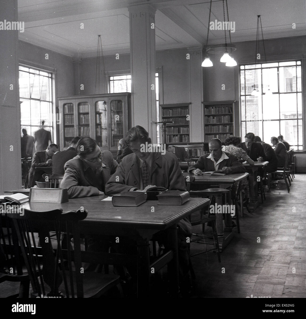 Historisches, 1950er Jahre, Leute sitzen an Tischen in einer Bibliothek lesen oder studieren. Stockfoto