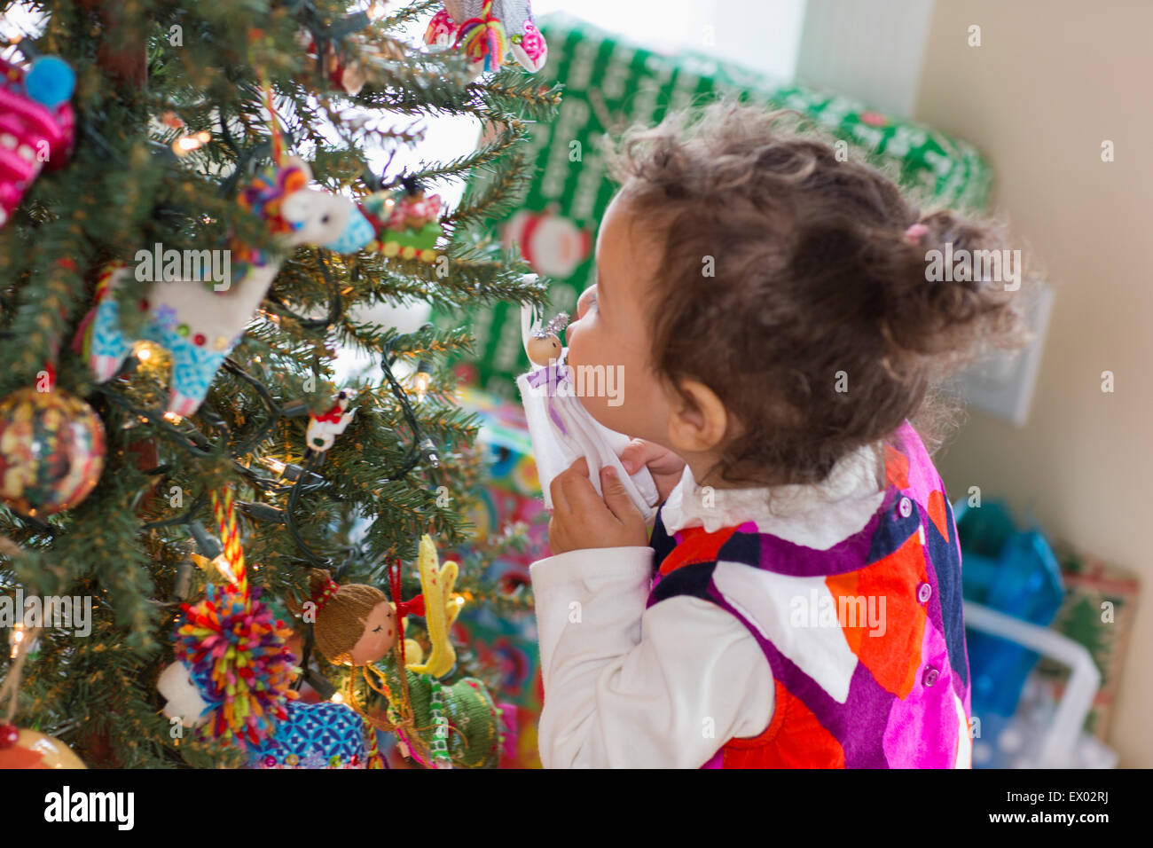 Kleines Mädchen küssen Engel Ornament am Weihnachtsbaum Stockfoto