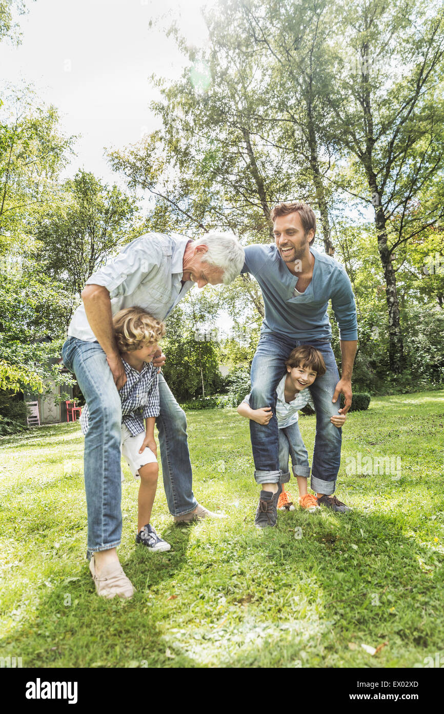 Mitte erwachsenen Mann mit Vater mit Söhnen im Garten spielen Stockfoto
