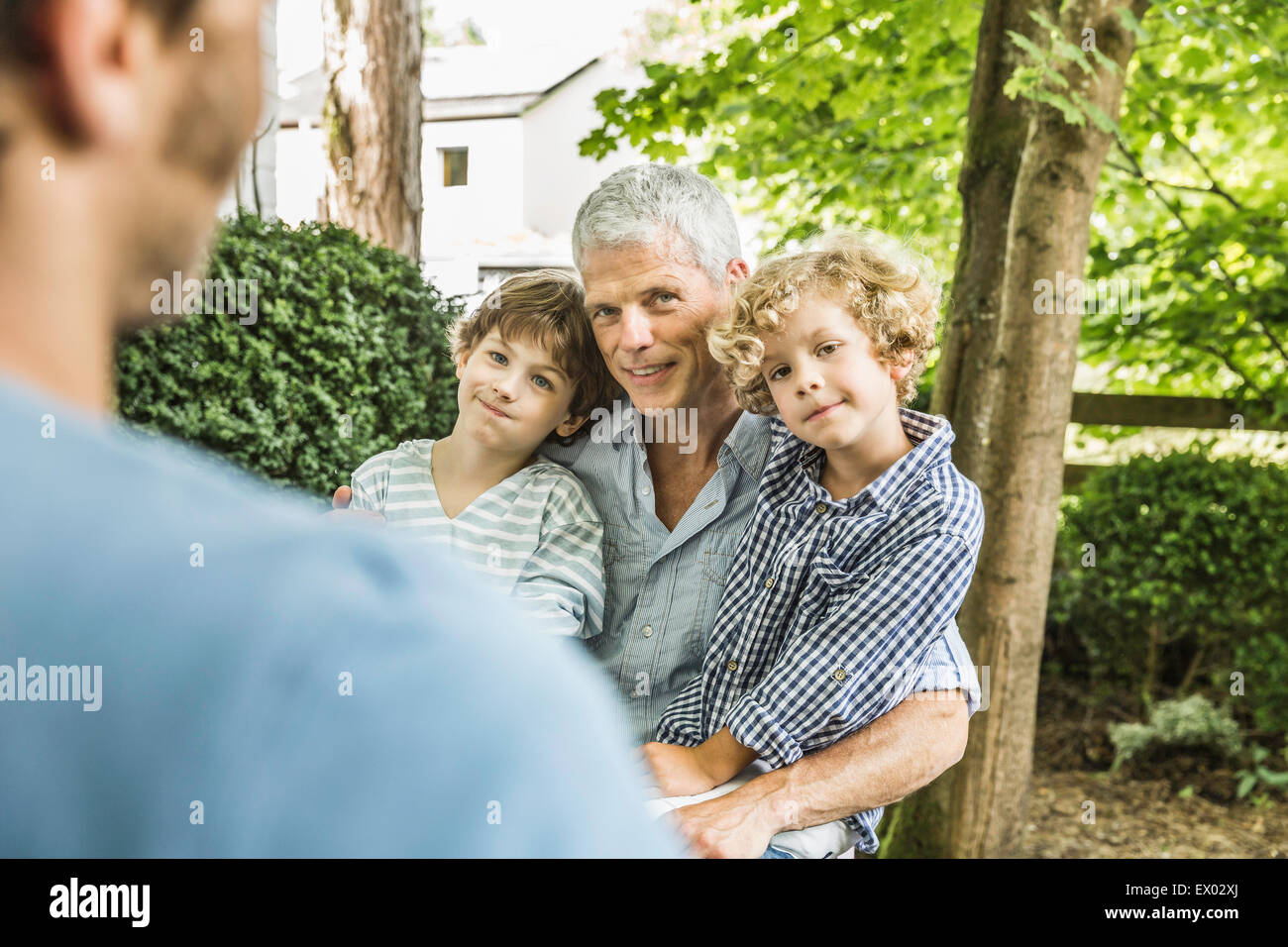 Mitte erwachsener Mann mit Vater und Söhnen im Garten Stockfoto