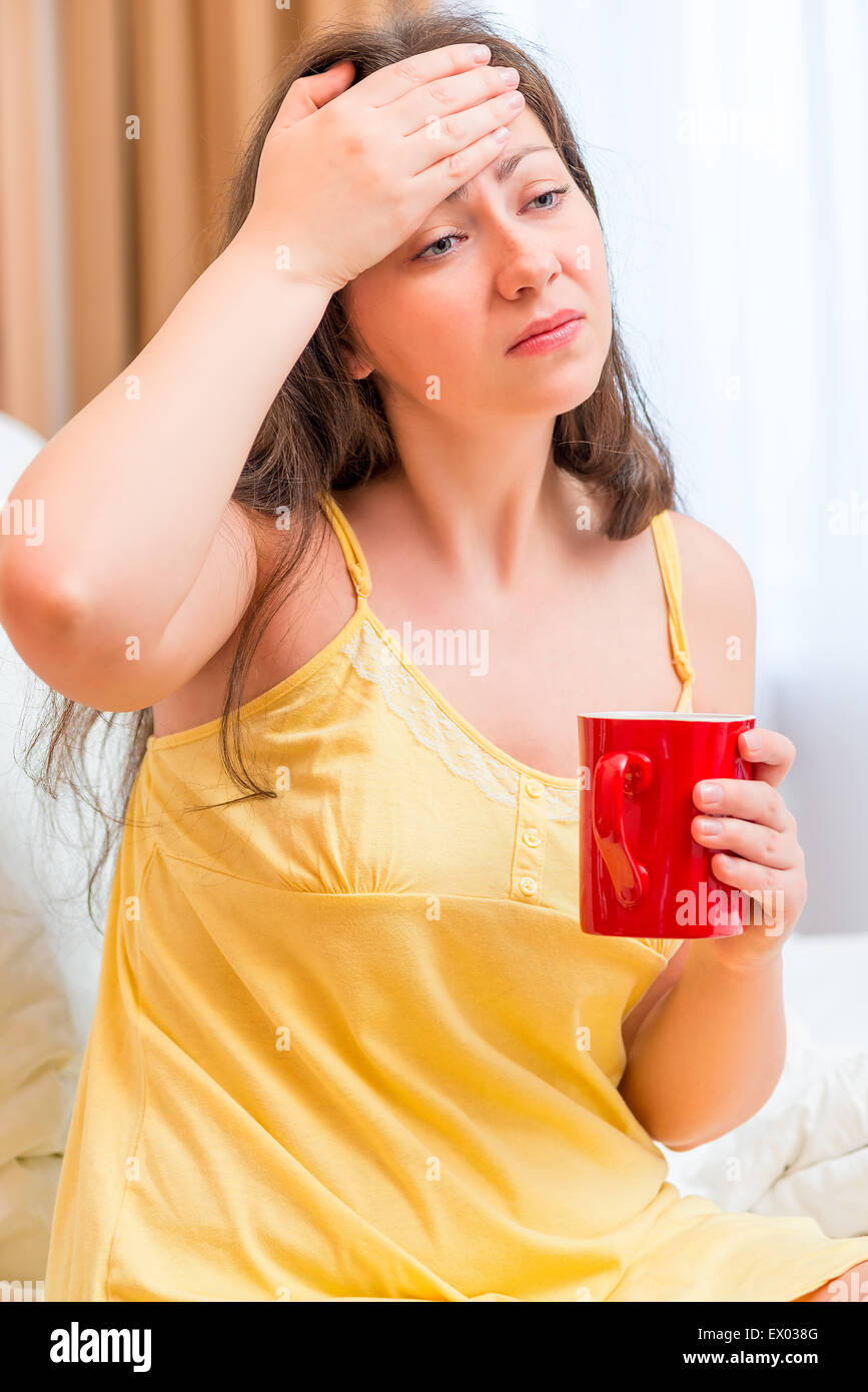 krankes Mädchen im Bett mit einer Tasse Tee Stockfoto