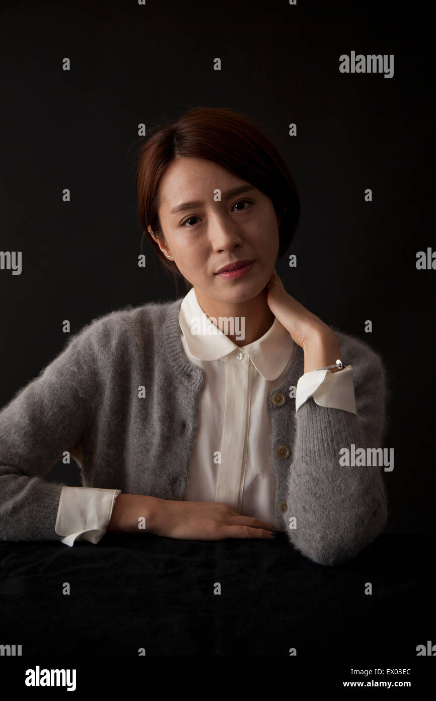 Porträt der Frau am Tisch sitzen Stockfoto
