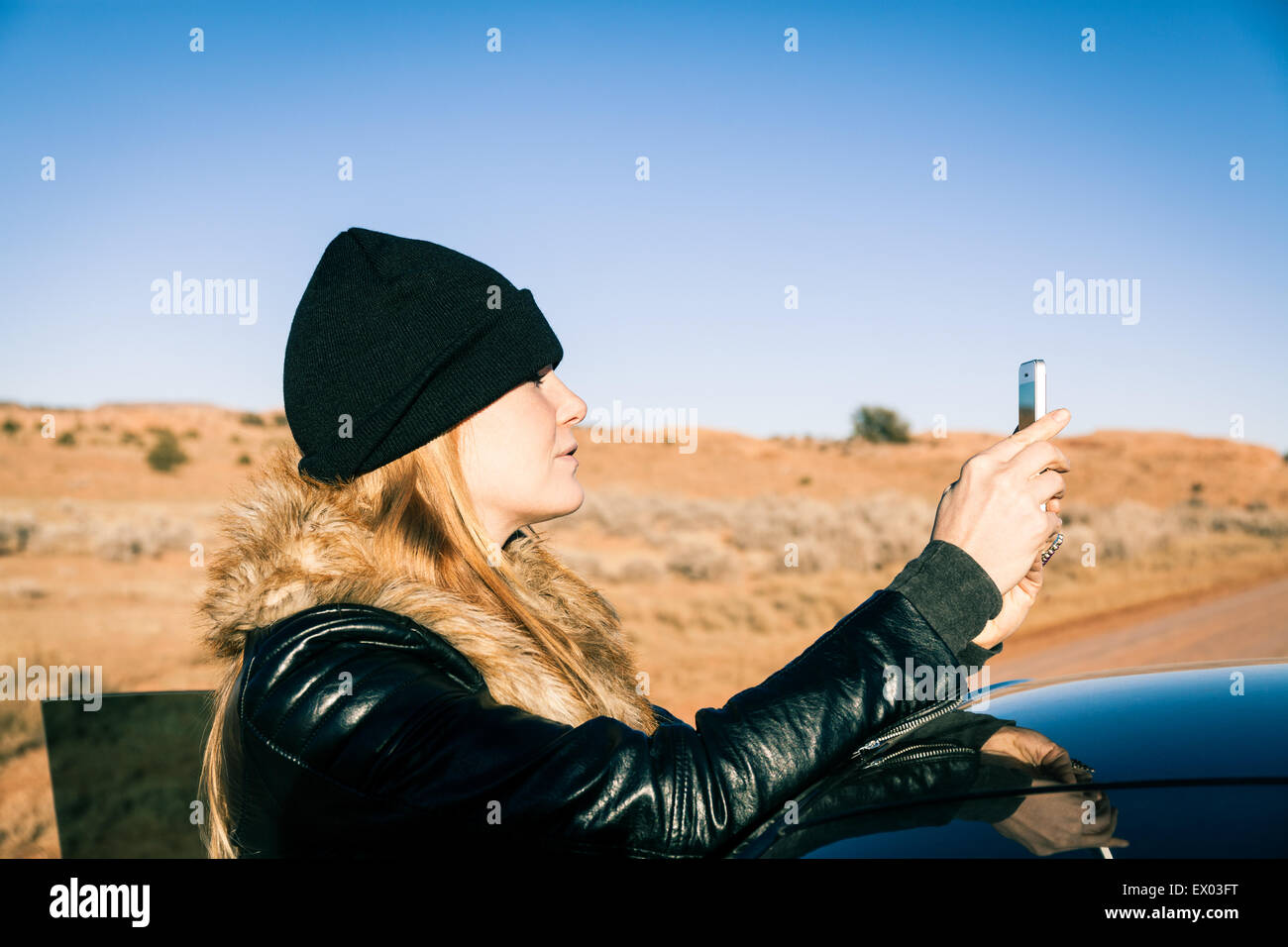Frau fotografieren neben Auto, Kayenta, Arizona, USA Stockfoto