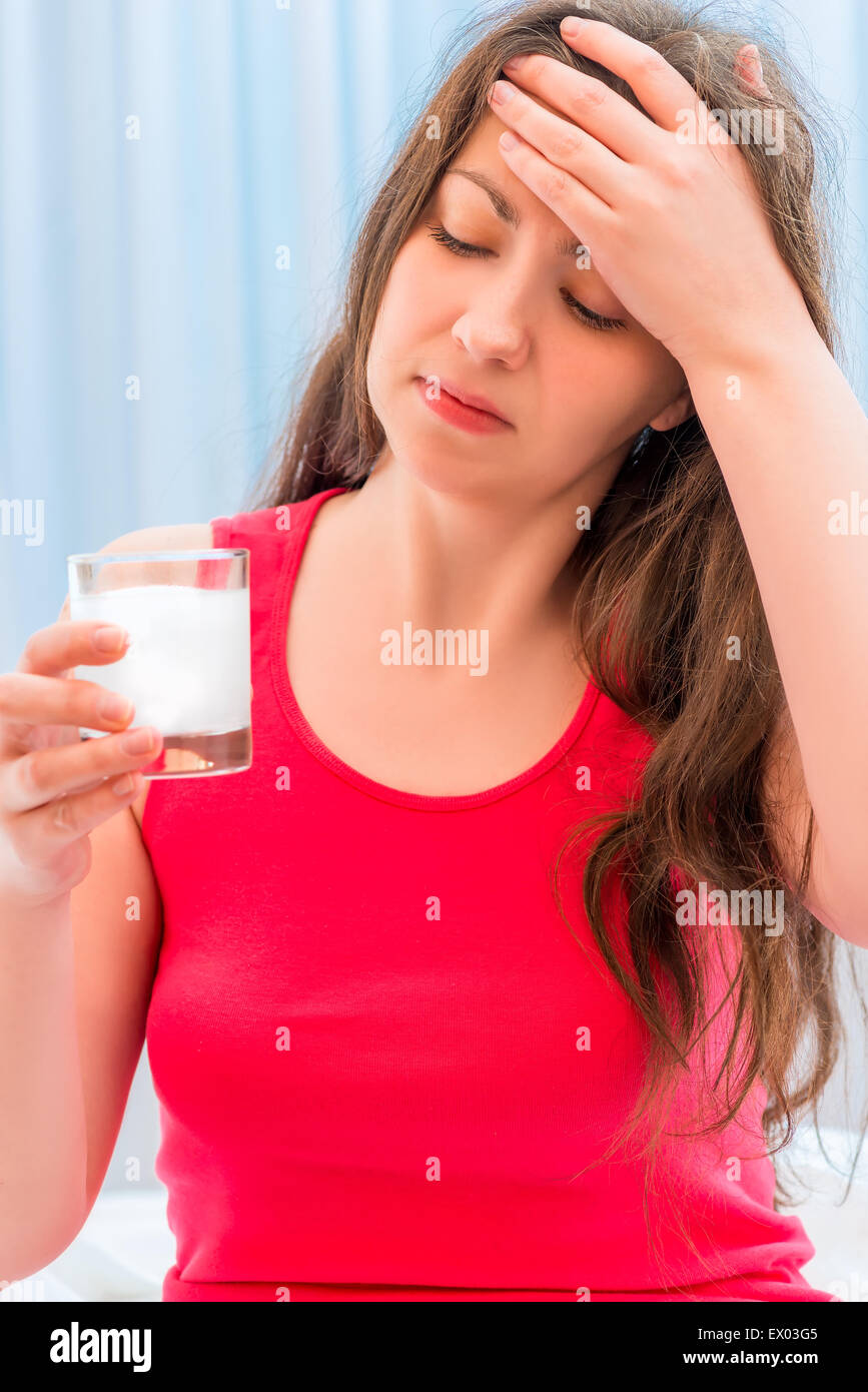 Mädchen mit einem Glas auflösendes Medikament Stockfoto