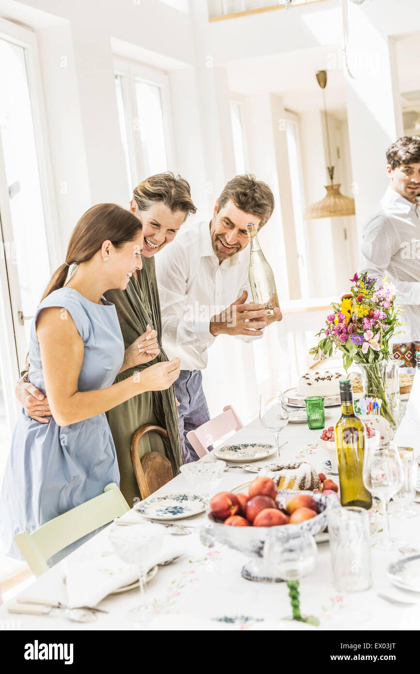 Paar und Erwachsene Tochter Vorbereitung Esstisch für party Stockfoto