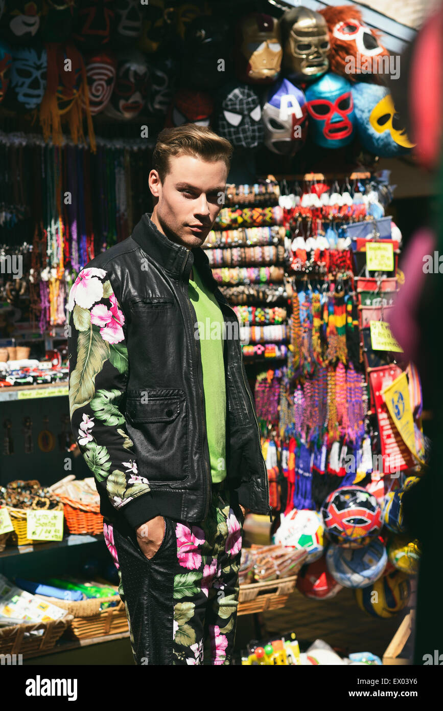 Ein Mann zu Fuß durch die lokalen im mexikanischen Markt auf Olvera Street in Los Angeles. Er steht, und prüfen Sie die bunten Produkt anzeigen. Stockfoto