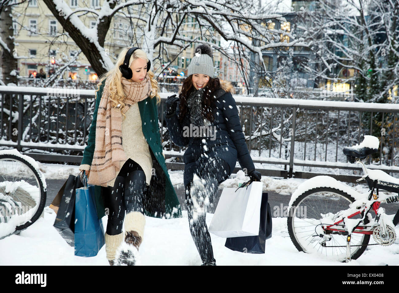 Zwei Frauen im Schnee mit Einkaufstüten Stockfoto