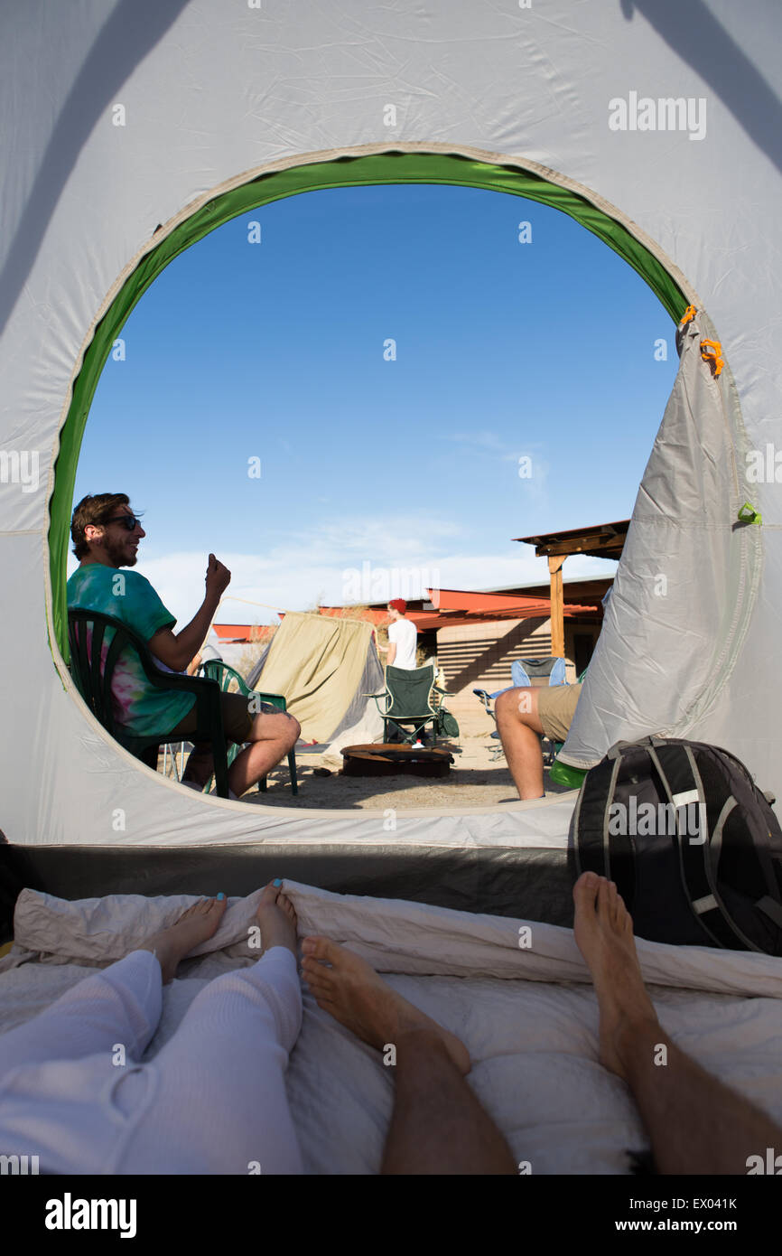 Junge Erwachsene Freunde innerhalb und außerhalb Zelt, Anza-Borrego Desert State Park, Kalifornien, USA Stockfoto