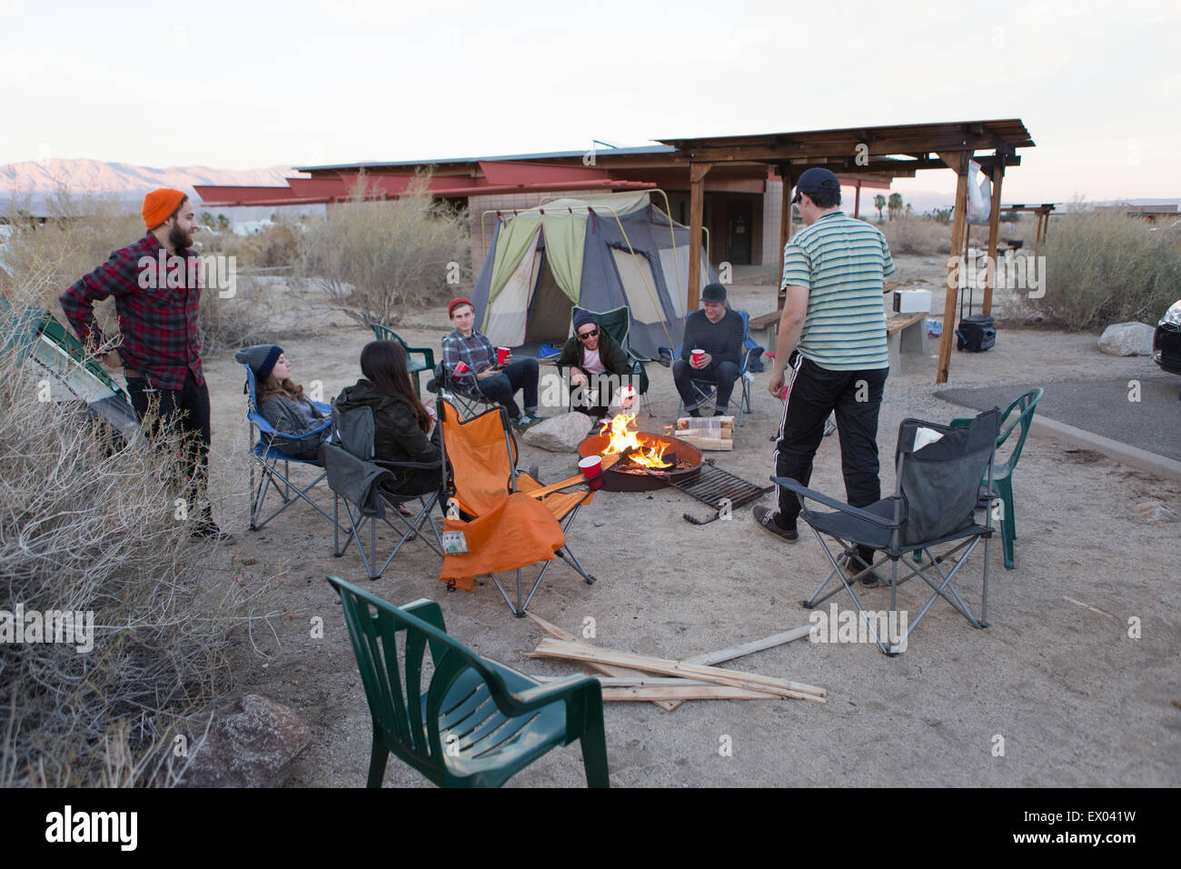 Junge Erwachsene Freunde sitzen im Chat um Lagerfeuer, Anza-Borrego Desert State Park, Kalifornien, USA Stockfoto