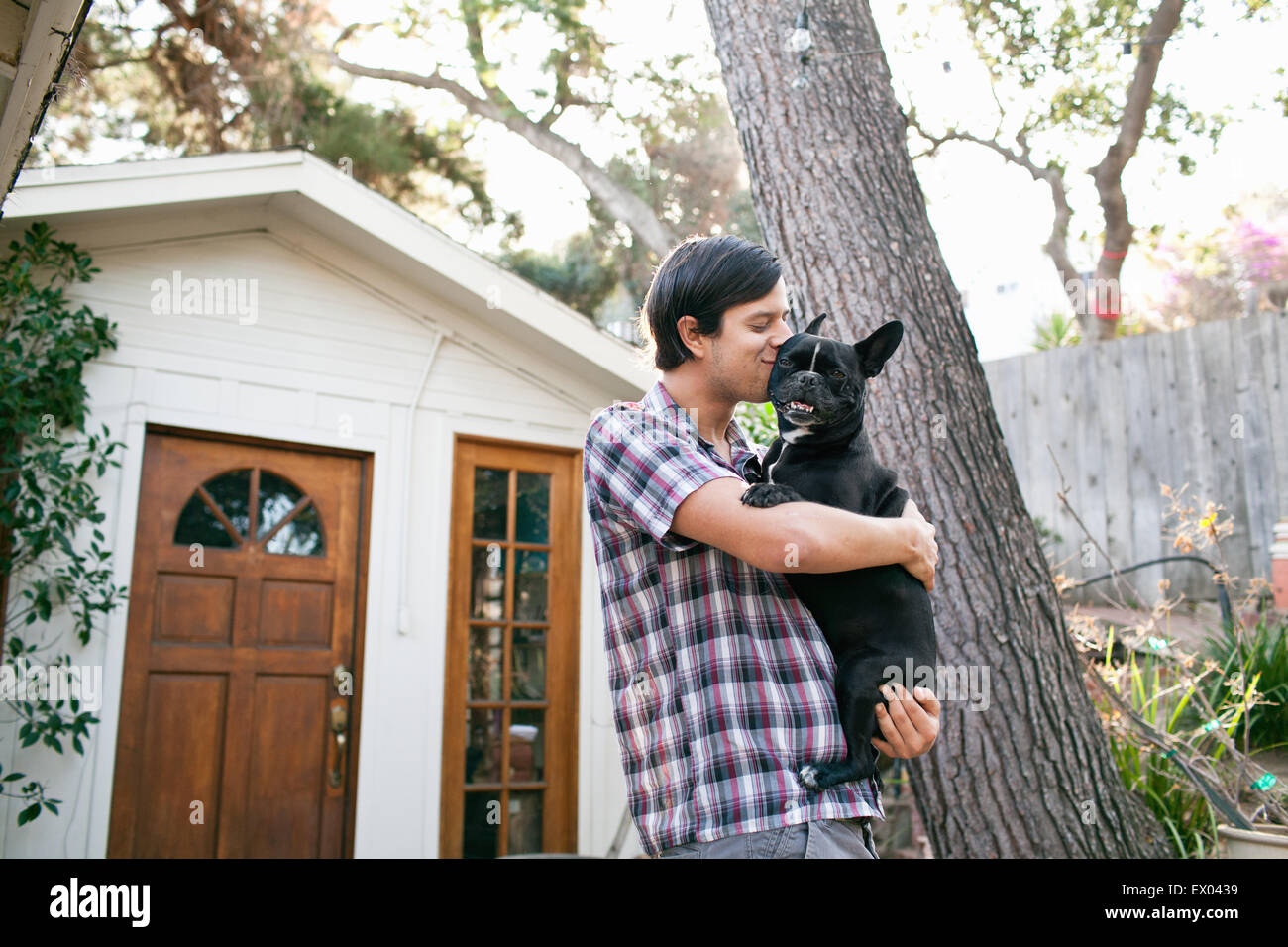 Junger Mann küssen Hund draußen vor der Tür Stockfoto