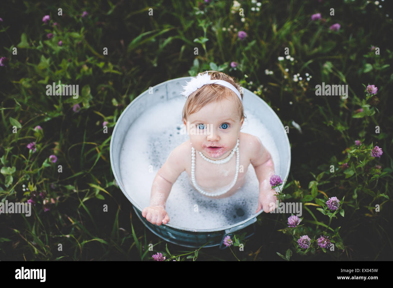Draufsicht des Mädchens in einer Zinn Badewanne in eine Wildblumenwiese Baden Stockfoto