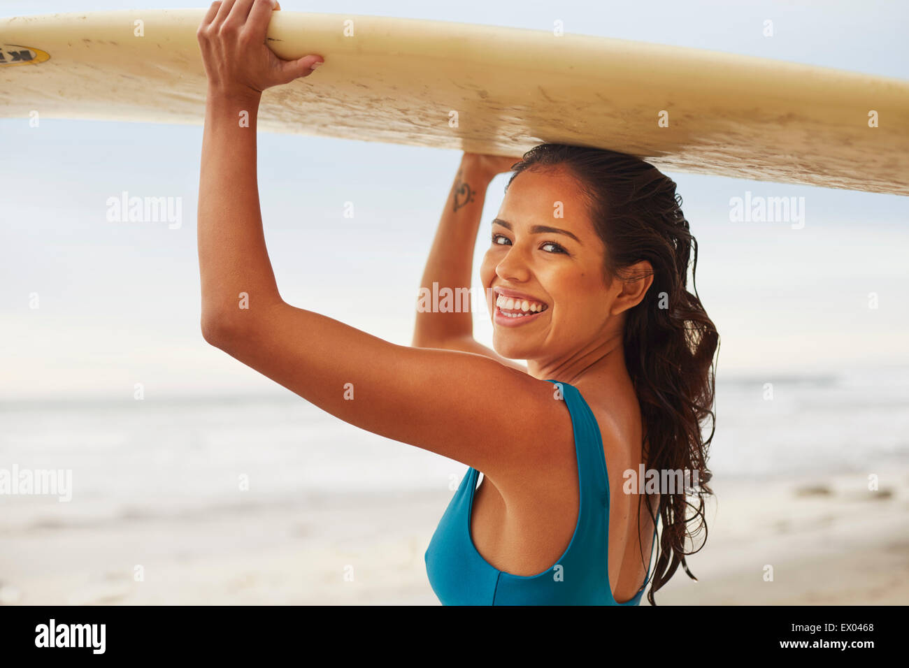 Porträt der lächelnde junge Frau mit Surfbrett auf Kopf am Beach, San Diego, Kalifornien, USA Stockfoto