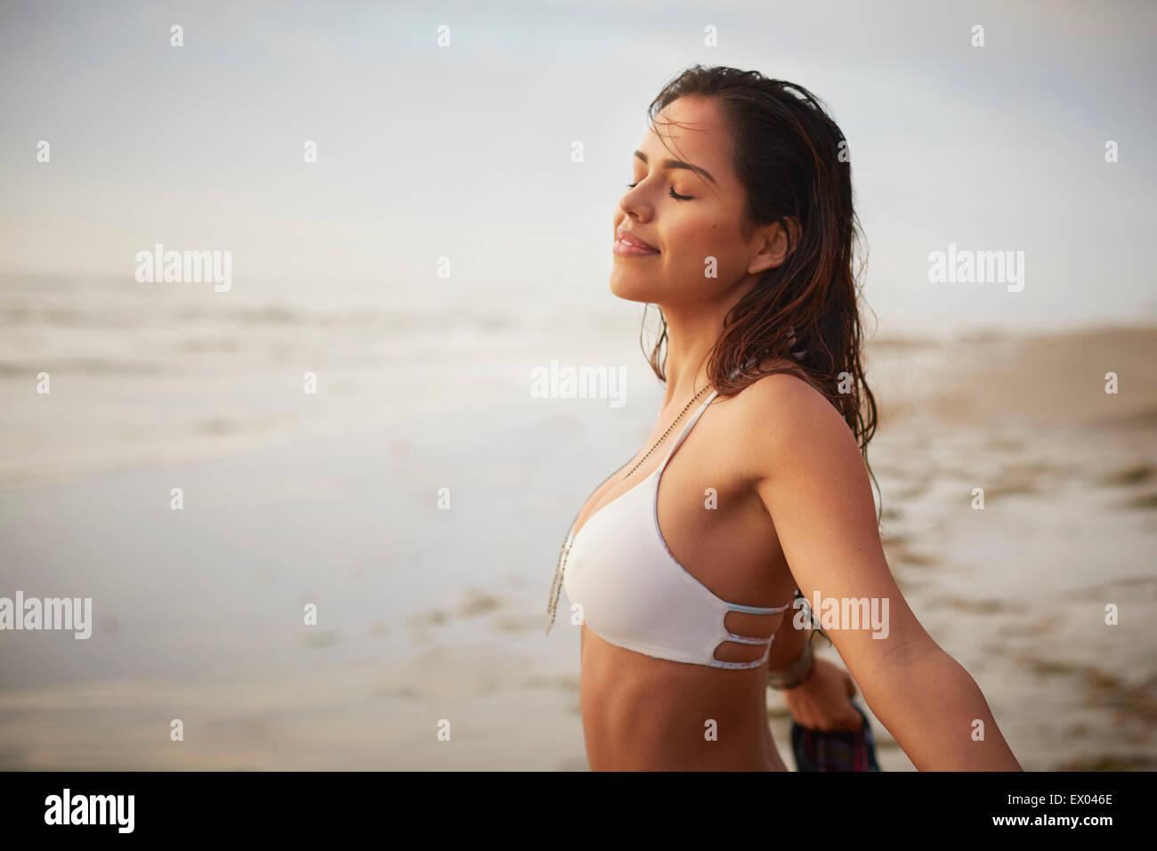 Porträt der lächelnde junge Frau mit Augen geschlossen tragen Bikini am Strand, San Diego, Kalifornien, USA Stockfoto
