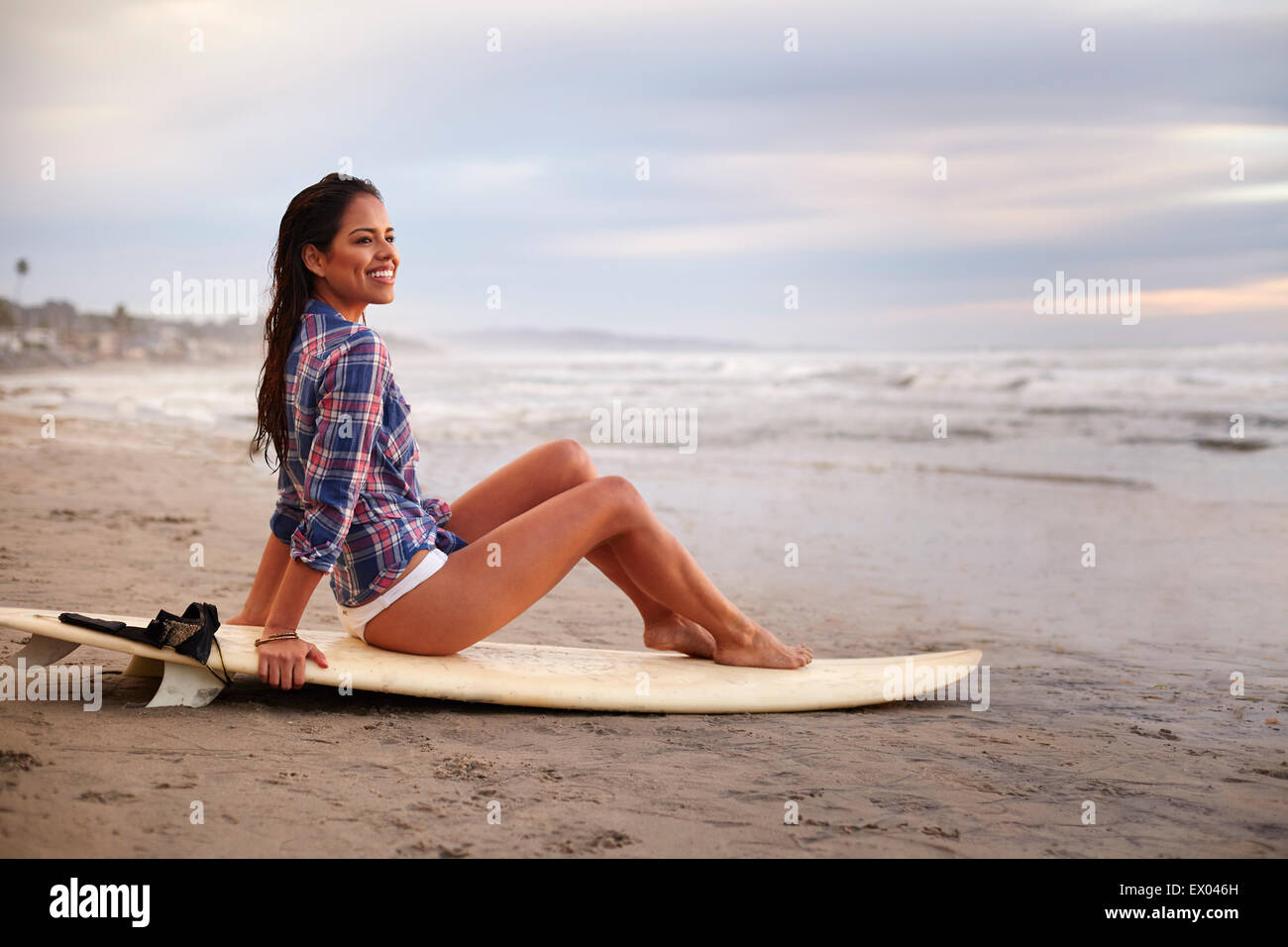 Junge Frau sitzt auf Surfbrett am Beach, San Diego, Kalifornien, USA Stockfoto