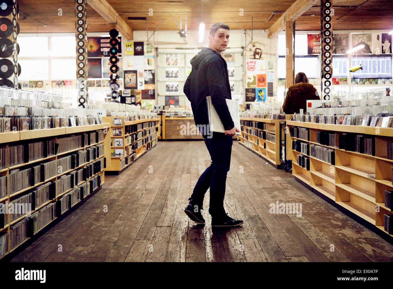 Junger Mann mit Vinyl-Schallplatte im Music store Stockfoto