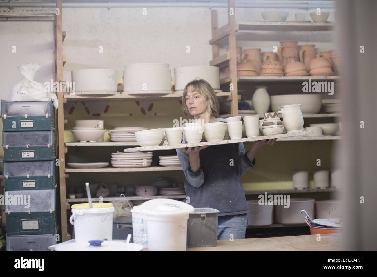 Weibliche Potter mit Tablett Tontöpfe in Werkstatt Stockfoto
