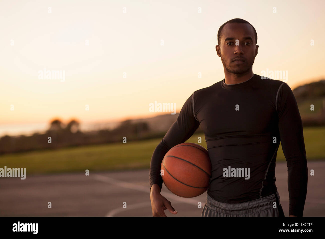 Porträt des jungen Mannes mit Basketball, im freien Stockfoto