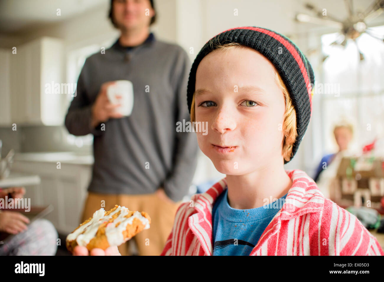 Porträt eines jungen essen Kuchen in Küche Stockfoto