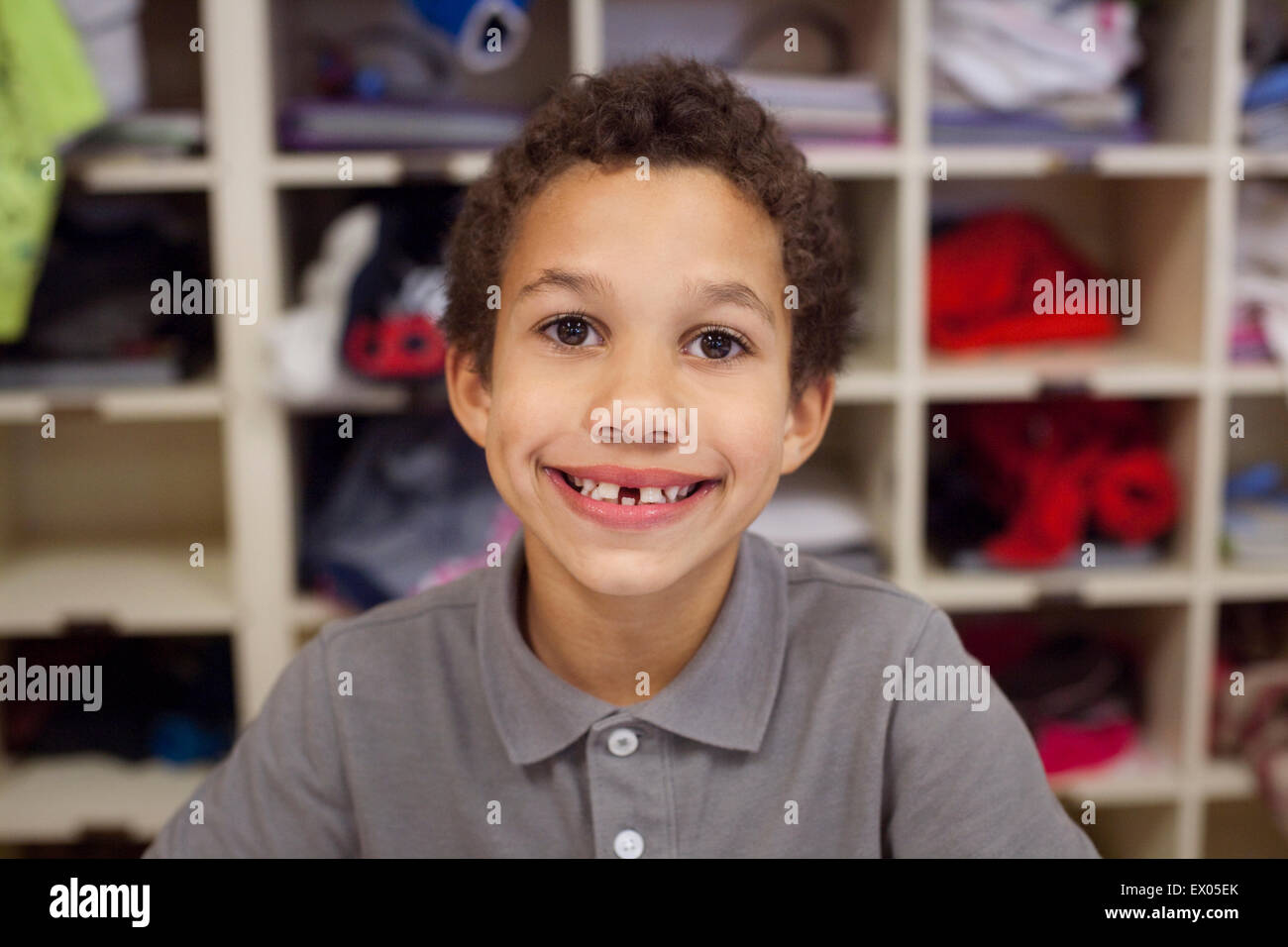 Junge mit breiten Lächeln, Regale im Hintergrund Stockfoto