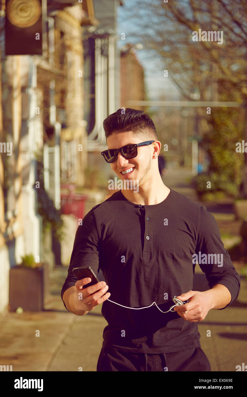 Junger Mann auf der Straße trägt Sonnenbrille Stockfoto